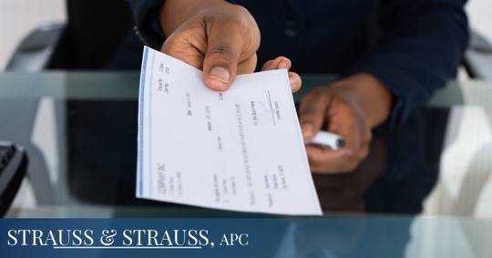Employer holding a paycheck towards the camera