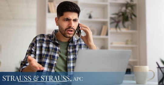 Frustrated man on the phone with his laptop open